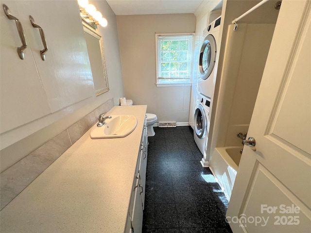 1111 S Skyland Dr, Mount Pleasant, NC 28124 - bathroom featuring vanity, baseboards, shower / bath combination, toilet, and stacked washing maching and dryer
