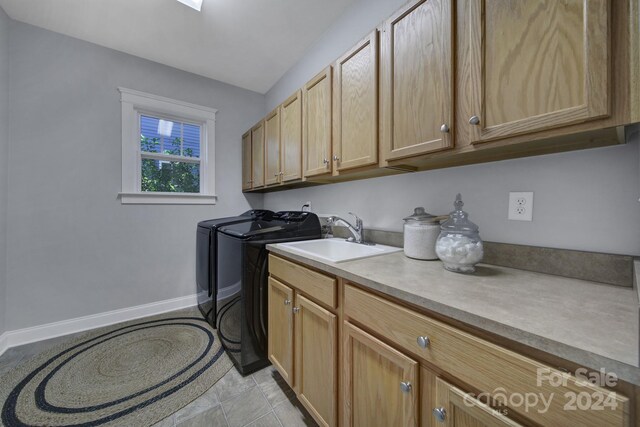 laundry area with washer and dryer, sink, and cabinets