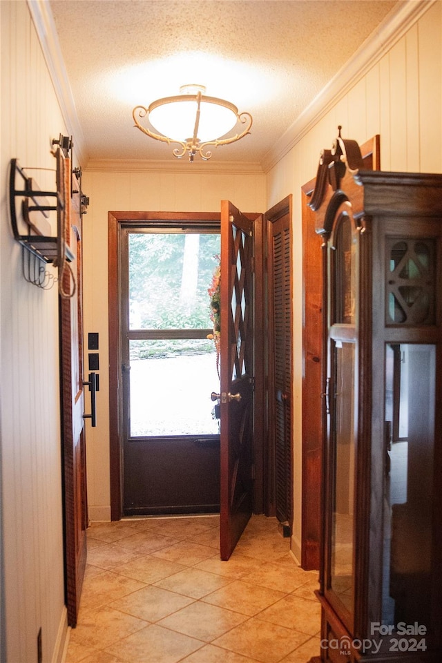 entryway featuring a textured ceiling and ornamental molding