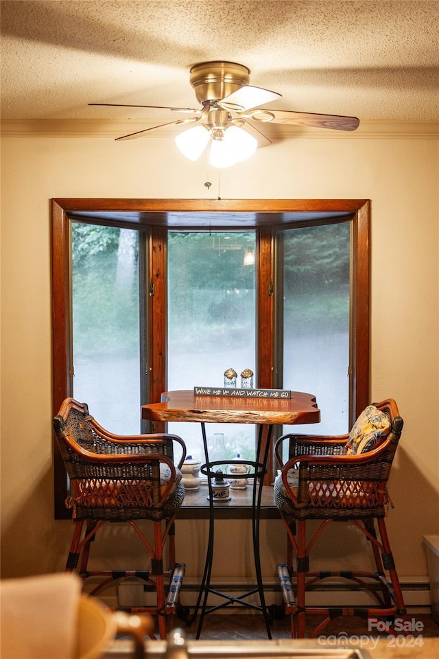 dining space featuring ceiling fan, a textured ceiling, and crown molding