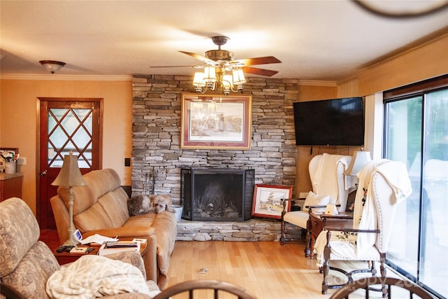 living room featuring ceiling fan, crown molding, a fireplace, and hardwood / wood-style floors