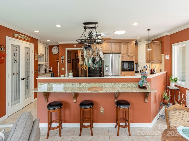 kitchen with a kitchen bar, black microwave, decorative light fixtures, and stainless steel refrigerator with ice dispenser