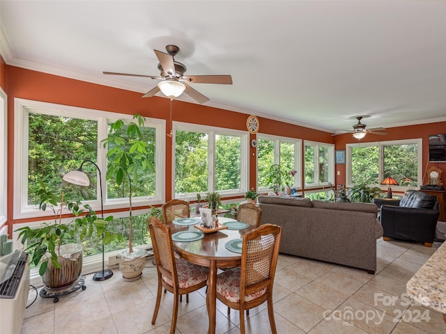 tiled dining room featuring ceiling fan, a healthy amount of sunlight, and ornamental molding