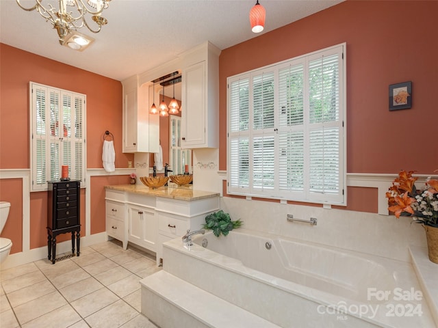 bathroom featuring tile patterned floors, a bathtub, vanity, a textured ceiling, and toilet