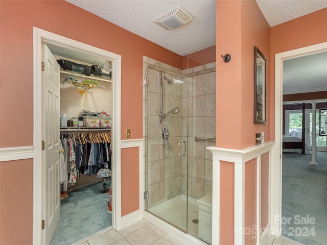 bathroom with tile patterned floors, a textured ceiling, and an enclosed shower