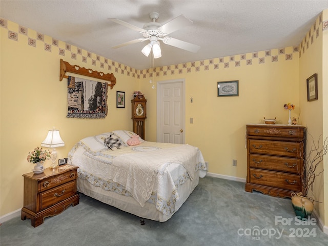 bedroom featuring carpet flooring, a textured ceiling, and ceiling fan