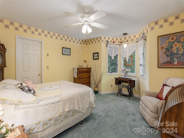 bedroom with a textured ceiling, carpet floors, and ceiling fan