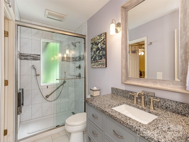 bathroom with toilet, a shower with door, vanity, and tile patterned flooring