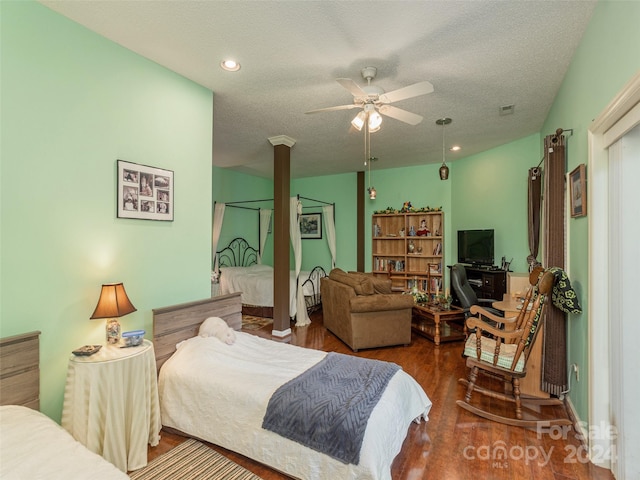 bedroom with a textured ceiling, hardwood / wood-style flooring, and ceiling fan