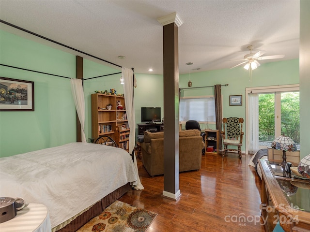 bedroom with ceiling fan, dark hardwood / wood-style flooring, and a textured ceiling