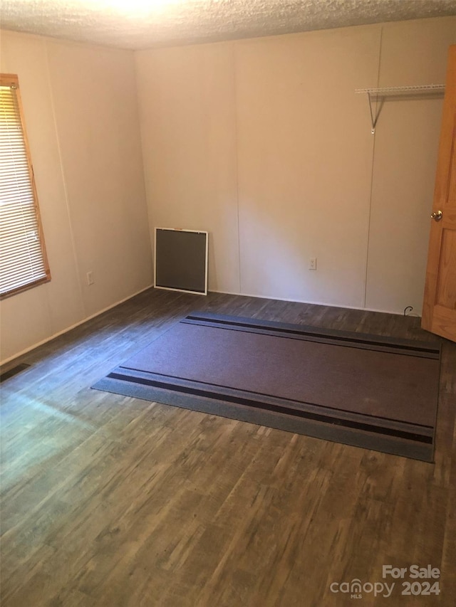 unfurnished room with a textured ceiling and hardwood / wood-style flooring