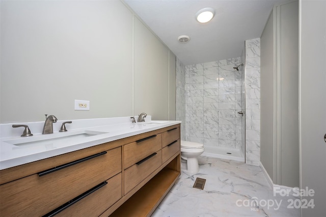 bathroom with toilet, vanity, and tiled shower