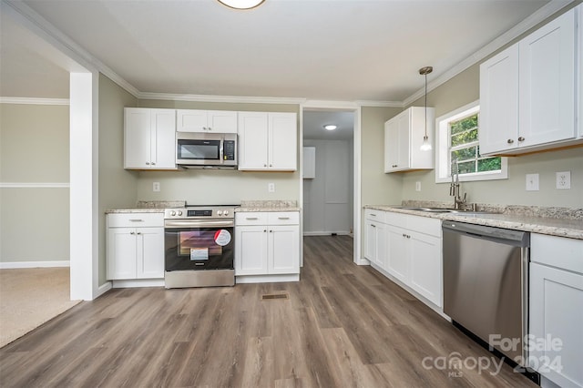 kitchen featuring stainless steel appliances, pendant lighting, white cabinetry, and sink