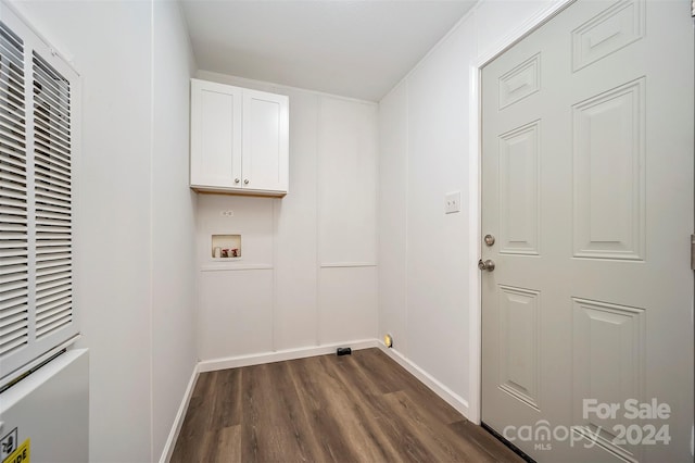 clothes washing area with dark wood-type flooring, hookup for a washing machine, and cabinets