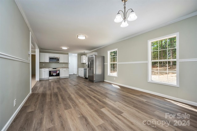 unfurnished living room with hardwood / wood-style flooring, crown molding, and a notable chandelier