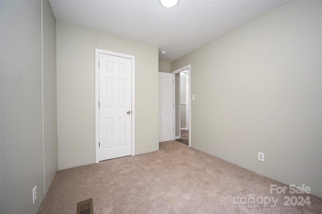 unfurnished bedroom featuring light carpet