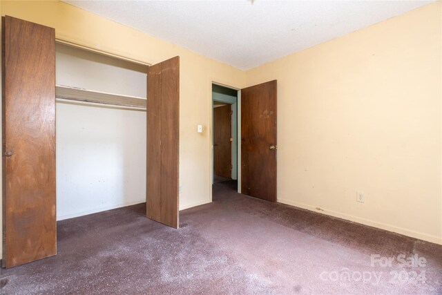 unfurnished bedroom featuring carpet floors and a closet