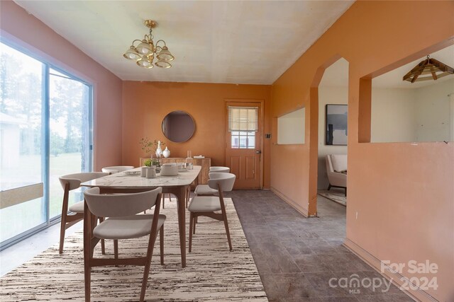 tiled dining room with a chandelier