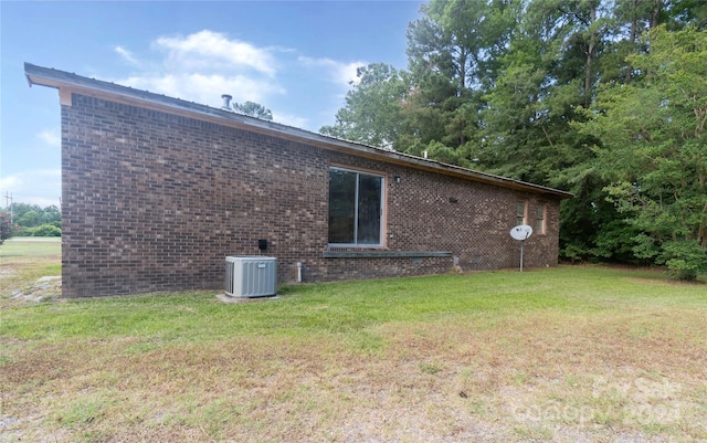 back of house with cooling unit and a lawn