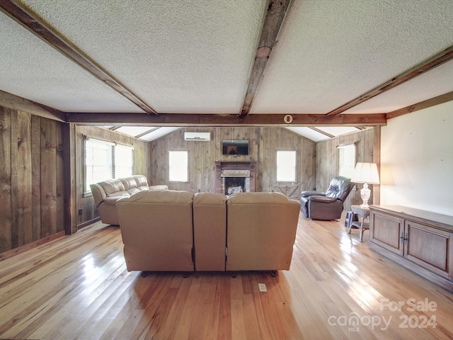 living room featuring a brick fireplace, a textured ceiling, light hardwood / wood-style flooring, and lofted ceiling with beams