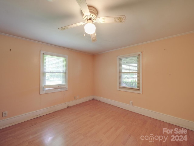 unfurnished room featuring light hardwood / wood-style floors, plenty of natural light, and ornamental molding