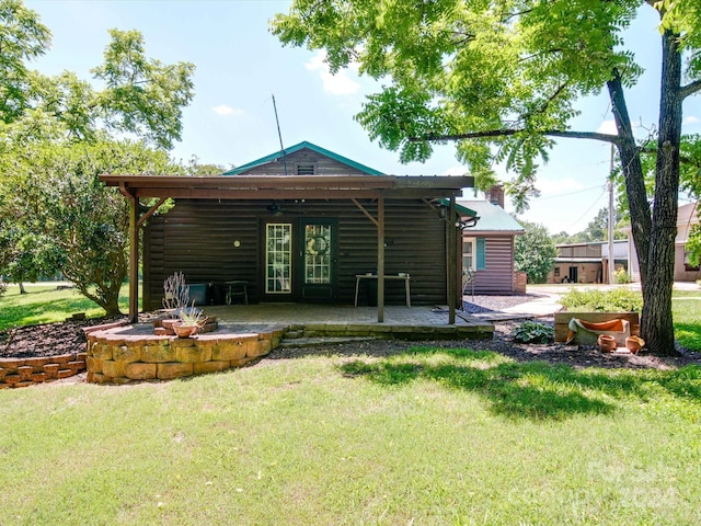 back of house with a patio area and a lawn