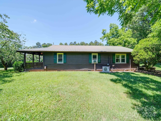 rear view of property with a lawn and ac unit