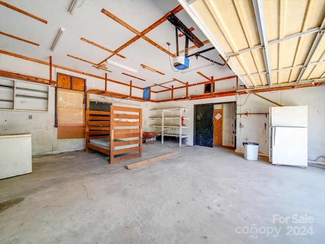 garage with a garage door opener and white fridge