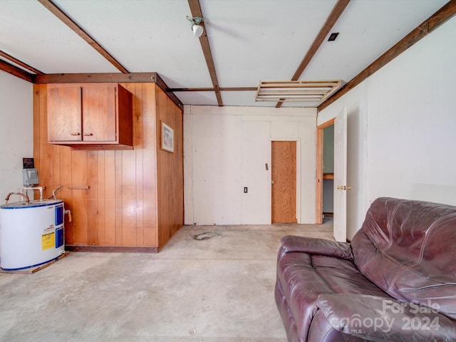 basement featuring water heater and wooden walls