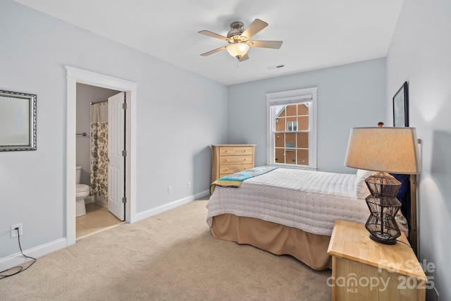 bedroom featuring carpet floors, ensuite bathroom, baseboards, visible vents, and ceiling fan