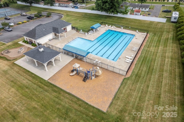 pool featuring fence and a yard