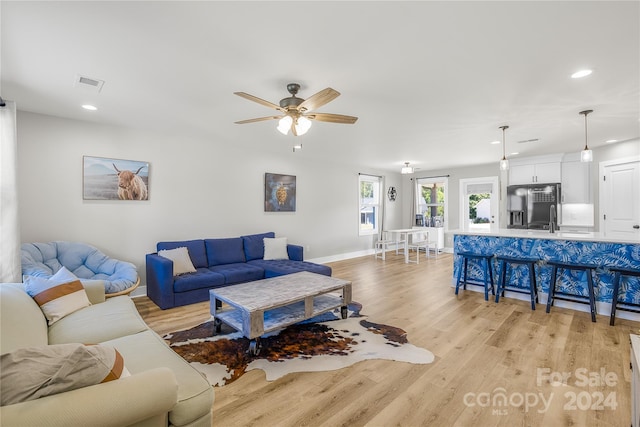 living room with ceiling fan and light wood-type flooring