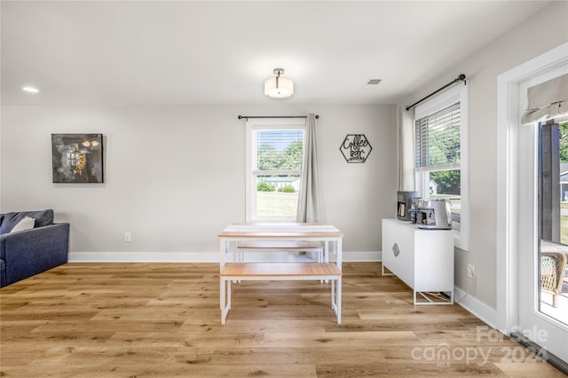 dining area with a wealth of natural light and light hardwood / wood-style flooring