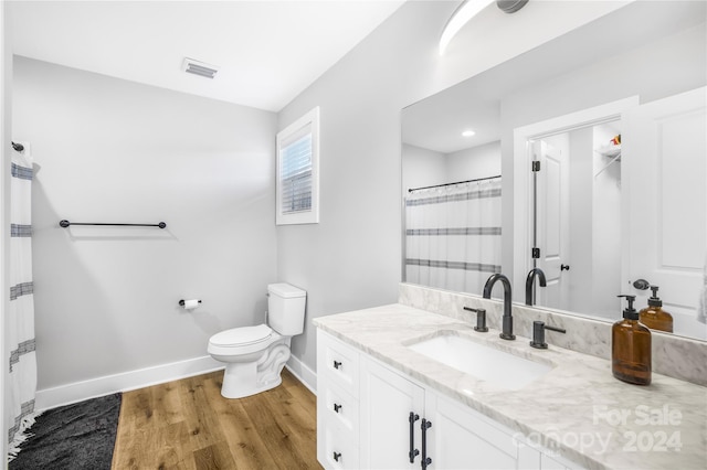 bathroom featuring toilet, walk in shower, wood-type flooring, and vanity