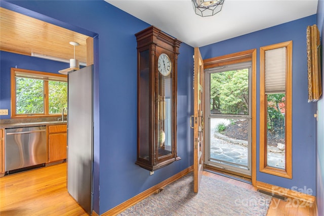 doorway featuring visible vents, light wood-style flooring, and baseboards