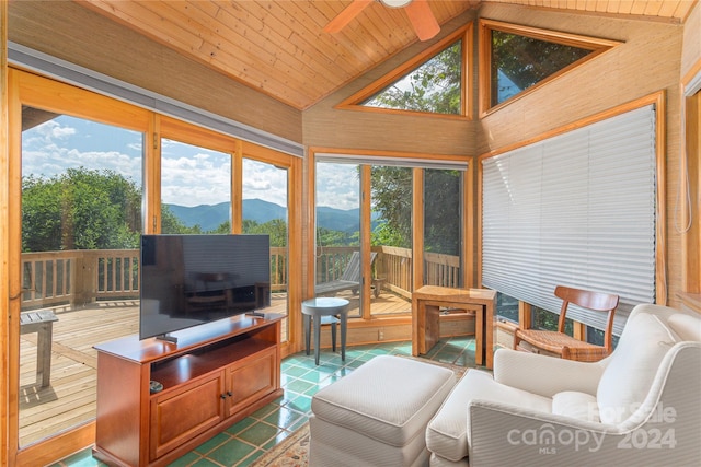 sunroom / solarium featuring a ceiling fan, wood ceiling, and vaulted ceiling