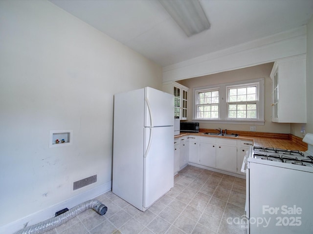 kitchen featuring white cabinetry, white appliances, and sink