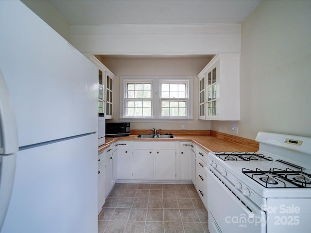 kitchen with sink, white cabinets, and white appliances