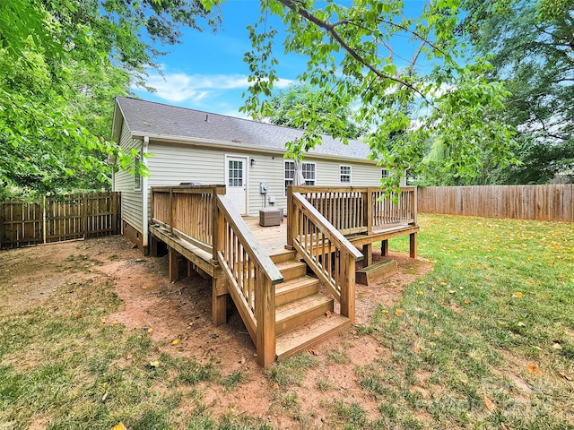 back of property featuring a deck and a lawn