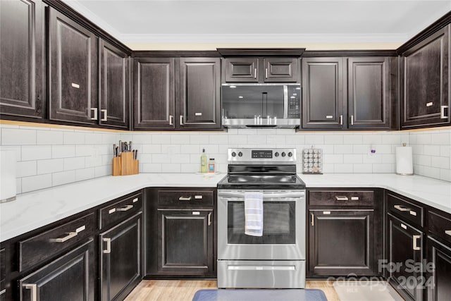 kitchen featuring appliances with stainless steel finishes, decorative backsplash, and dark brown cabinetry