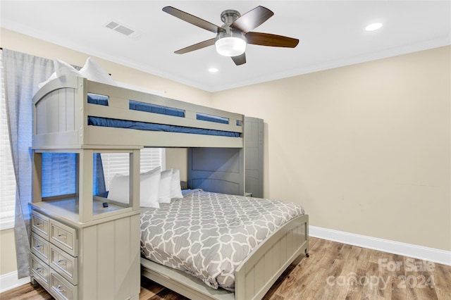 bedroom featuring ceiling fan, light hardwood / wood-style floors, and crown molding