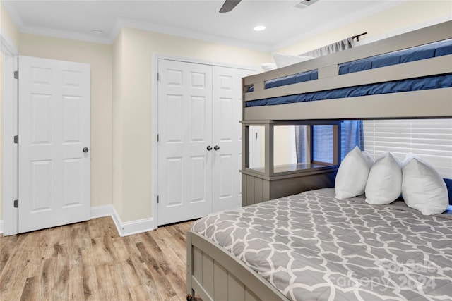 bedroom with ceiling fan, a closet, crown molding, and light hardwood / wood-style flooring