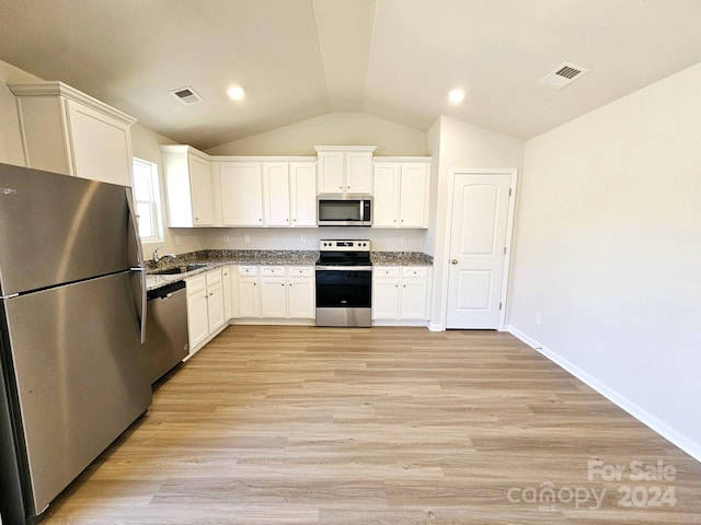 kitchen featuring white cabinetry, sink, light hardwood / wood-style floors, vaulted ceiling, and appliances with stainless steel finishes