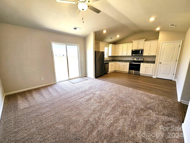 kitchen with black appliances, dark colored carpet, vaulted ceiling, ceiling fan, and white cabinetry