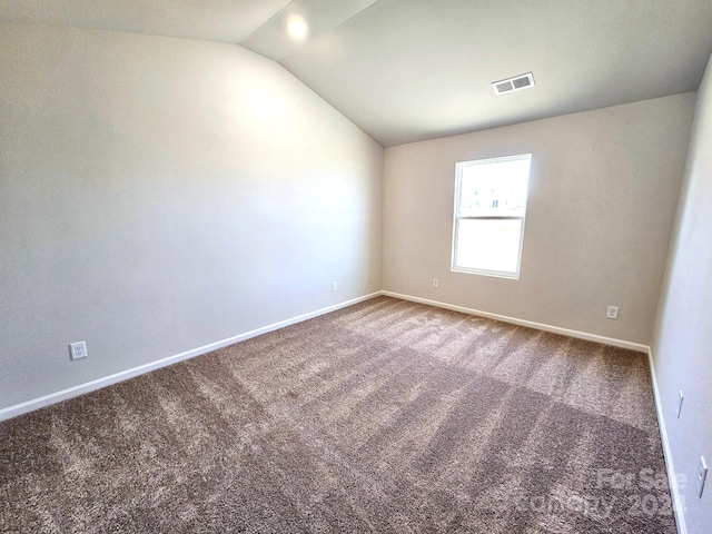 spare room with carpet and lofted ceiling