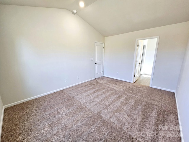 carpeted spare room with lofted ceiling