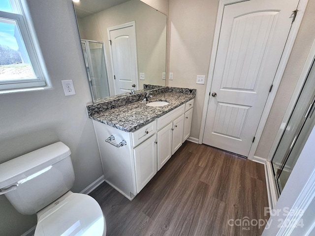 bathroom with hardwood / wood-style flooring, vanity, toilet, and walk in shower