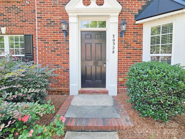 property entrance featuring brick siding