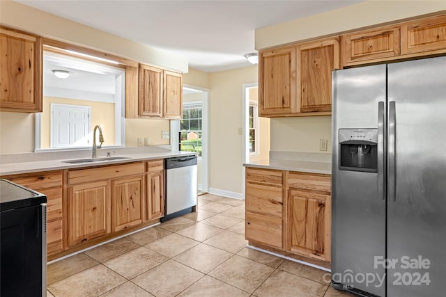 kitchen featuring light tile patterned flooring, stainless steel appliances, and sink