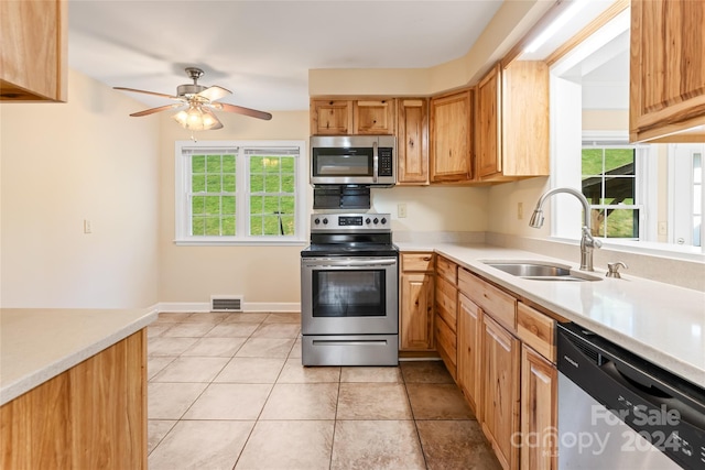 kitchen featuring light tile patterned floors, stainless steel appliances, ceiling fan, and sink